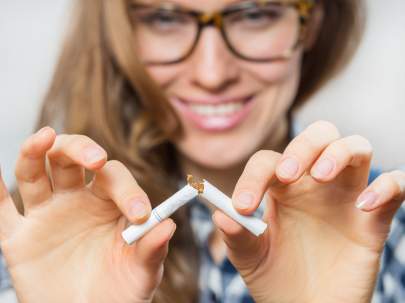 A woman breaking a cigarette in two